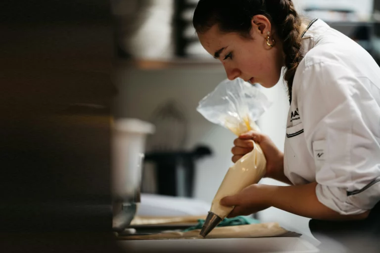 Pastry chef decorating desserts in professional kitchen at Catering by Bryce Utah