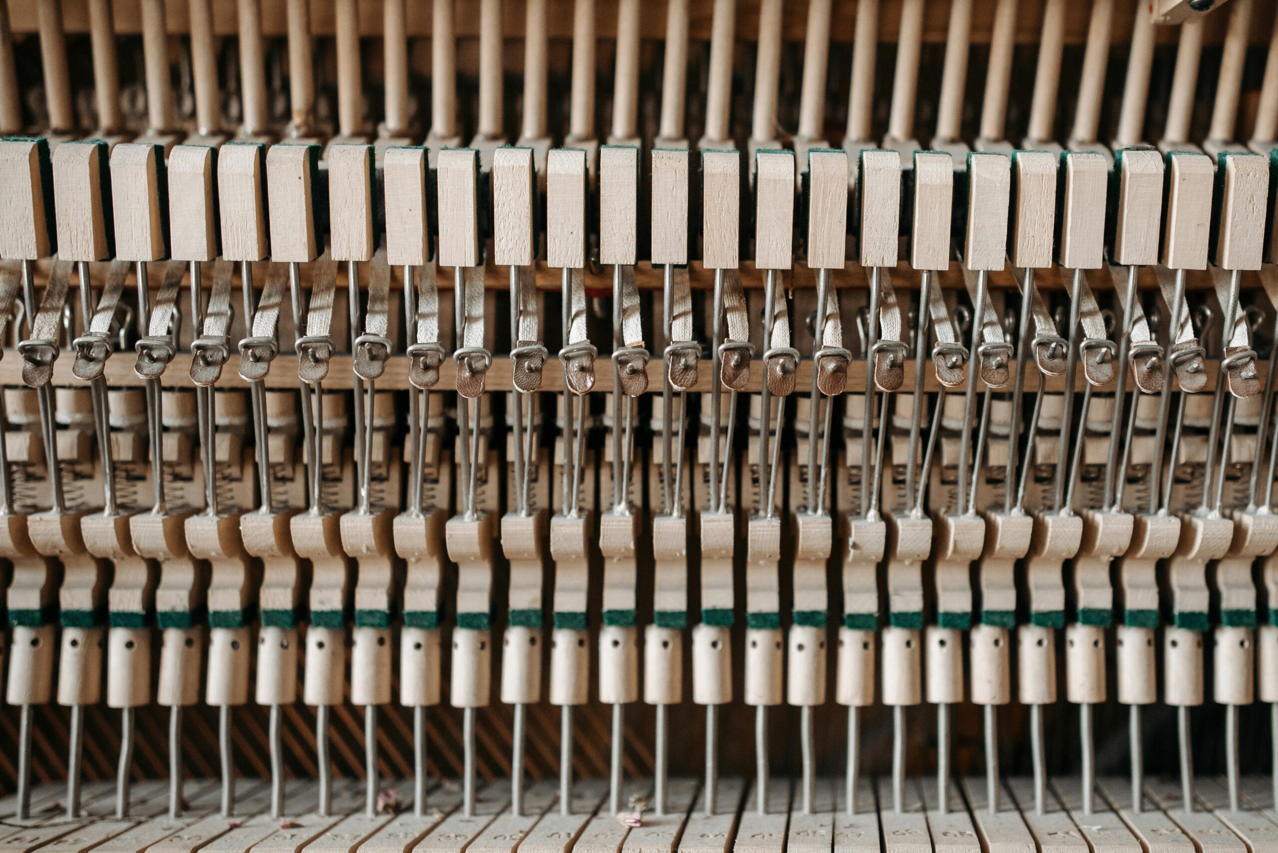 Detailed close-up of piano action mechanism showing hammers and strings.